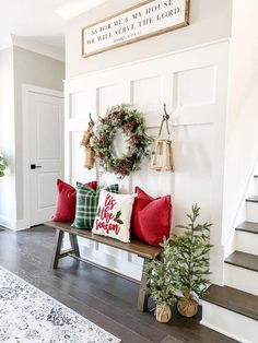 the entryway is decorated for christmas with wreaths and holiday decorations on the bench