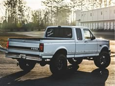 a white ford truck parked in a parking lot