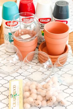 the table is set up with cups, bowls and other things to make it look like they're making something out of clay