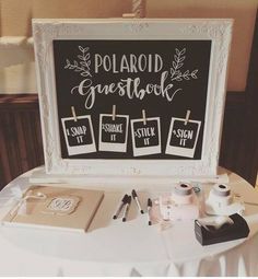 there is a sign that says polaroid guest book on the table with other items