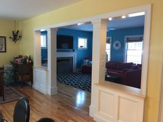 a living room filled with furniture and a fire place under a mirror on the wall