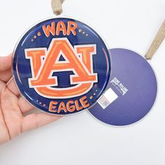 Licensed by Auburn University *Please allow 3-5 business days in addition to regular processing time for this item* Deck the halls with Auburn pride this holiday season with an ornament that is the perfect way to show off your school spirit and bring a touch of Tiger tradition to your festive decorations. This shiny, clear acrylic ornament is a digital print by New Orleans' artist Kristin Malone. Ornament measures 4" wide x 4" tall x 1/8" thick. Hangs approximately 6" with ribbon. See all of the Auburn Door Hangers, Auburn Ideas, Auburn Logo, Diy Xmas Ornaments, Auburn University, Graduation Party Decor, Xmas Ornaments, Deck The Halls, School Spirit