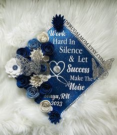 a blue graduation cap decorated with flowers on top of a white furnishing area