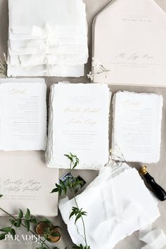 the wedding stationery is laid out on top of each other, including napkins and rings