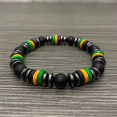 This stretch bracelet is made of black 8mm round black matte onyx beads, 8mm black, green and yellow ceramic rondelle beads and 8mm hematite rondelle beads. Please select your WRIST SIZE. If you have any questions about sizing, please don't hesitate to ask. I'm here to help. :) Please keep in mind that the final design of the bracelet may be a little different from the picture due to the addition or subtraction of beads needed to make your bracelet the correct size. I will strive to get it as close as possible. Casual Black Hematite Jewelry, Black Hematite Magnetic Bracelets, Black Magnetic Hematite Bracelet, Black Hematite Magnetic Bracelet, Black Magnetic Hematite Bracelets, Black Hematite Bracelets With Spacer Beads, Black Beaded Hematite Stretch Bracelet, Jamaican Flag, Yellow Ceramics