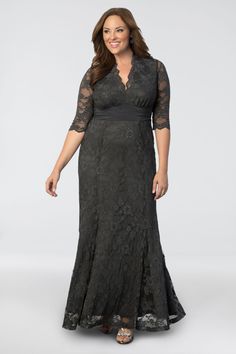 a woman wearing a black lace dress with sleeves and an open v - neckline