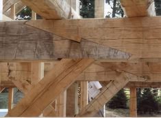 an unfinished wooden structure with windows in the background