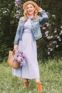 a woman in a dress and hat holding a basket