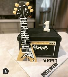 a guitar shaped cake sitting on top of a table next to a amplifier and amp