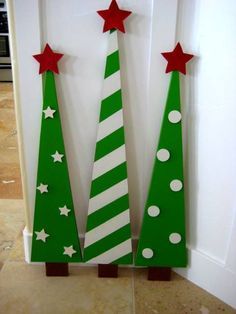 two wooden christmas trees with red and white stars on them