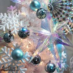 a white christmas tree with blue and silver ornaments