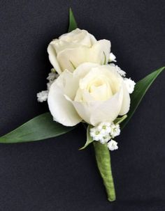 two white roses and baby's breath boutonniere on a black background