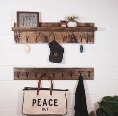 two wooden shelves with coat hooks and a bag hanging on the wall next to it