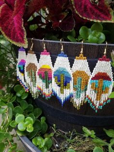 the beaded earrings are hanging from a potted plant