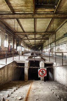 an abandoned building with no parking sign in the middle