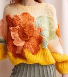 a woman wearing a sweater with flowers on it