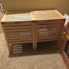 a wooden bed frame with slats on the bottom and sides, in front of a mirror