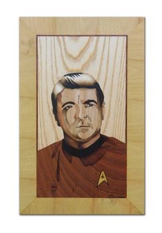 a wooden plaque with a star trek portrait on it