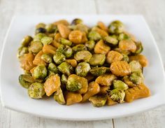 brussel sprouts on a white plate with oranges and raisins