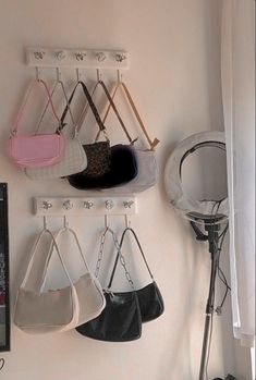 several purses hanging from hooks on a wall