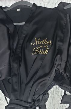 mother of the bride robe laying on top of a white furnishing area with gold lettering