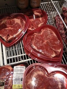 several heart shaped meats are on display in the freezer at a grocery store