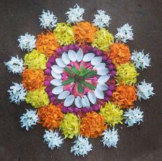 an overhead view of flowers arranged in a circular arrangement on the ground with one flower center surrounded by smaller ones