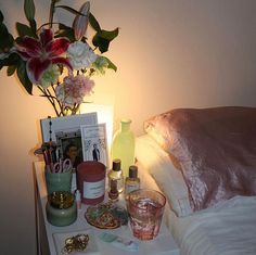 a night stand with flowers and other items on it