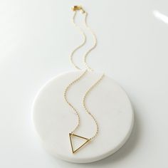 "Beautiful and lovely gold triangle charm necklace. Made of gold triangle charm and skinny gold plated brass chain. Soft and warm. Great for gift, everyday or special occasion. Your will ship in a gift box. Please feel free to contact me if you have any question :) ♥ Chain length 14\"-20\" ♥ Triangle 3/4\" ♥ Gold plated over brass ♥ Delivery Time Fast shipping within 1 - 3 days ♥ See more Rudiana Accessories Rudiana.etsy.com" Gold Geometric Minimalist Necklace, Minimalist Gold Geometric Necklace, Minimalist Pyramid-shaped Jewelry For Gifts, Minimalist Triangle Brass Jewelry, Minimalist Geometric Gold Necklace, Gold Triangle Brass Jewelry, Gold Triangle Necklace For Gift, Triangle Necklace With Adjustable Chain For Gift, Dainty Gold Triangle Jewelry