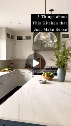 a kitchen with white cabinets and an island in front of the counter top that has fruit on it