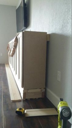 a flat screen tv sitting on top of a wooden floor next to a wall mounted television