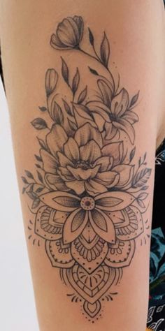 a woman's thigh with a flower tattoo on it