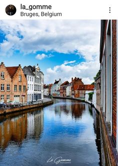 a river running through a small town next to tall brick buildings on either side of it