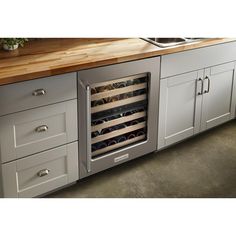 a kitchen with an oven, sink and counter top that has wine bottles in it