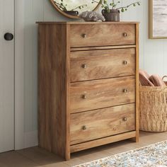 a wooden dresser sitting in front of a white door with a round mirror above it