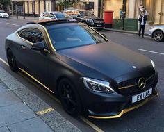 a black car parked on the side of a street