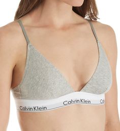 Soft cotton stretch bralette with elastic logo band. Made of cotton, modal, polyamide, polyester and elastane. Wireless, cotton-blend cups are lined with same fabric with vertical darts for shape. Deep V-neckline has covered elastic edge. Soft sewn-on Calvin Klein elastic underband. Sides and back are stretch cotton with covered elastic at top and underband at bottom. Narrow, center pull straps are soft restricted stretch elastic that fully adjusts at back with coated metal hardware. Convertible Calvin Klein Long Sleeve Bra, Ck Grey Bra, Fitted Cotton Sports Bra With Light Support, Fitted Cotton Sports Bra With Adjustable Straps, Seamless Cotton Bra, Cotton Sports Bra With Light Support, Fitted Casual Cotton Bra, Casual Fitted Cotton Bra, Cotton Fitted Bra For Loungewear