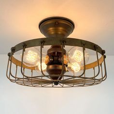 an old fashioned light fixture with four bulbs on it's caged wire frame