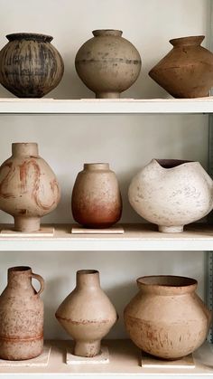 many different vases on shelves in a room