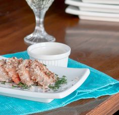 some food is sitting on a white plate and next to a small glass bowl with something in it