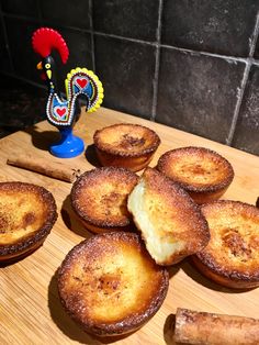 baked pastries sitting on a cutting board next to cinnamon sticks and a small figurine