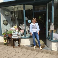 a woman standing in front of a store window