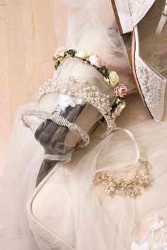 a pair of bridal shoes sitting on top of a white cloth covered floor next to a veil