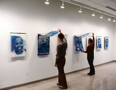 two people looking at paintings on the wall