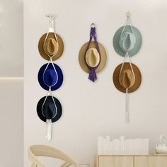 three hats hanging on the wall next to a chair