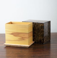 two wooden boxes sitting on top of a wooden table next to each other and one is empty