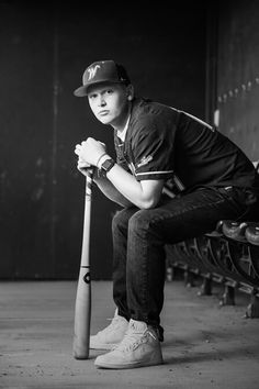 a man sitting on a bench holding a baseball bat