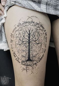 a woman's thigh with a tree tattoo on it