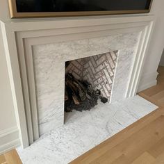 a fireplace with white marble and gold trim