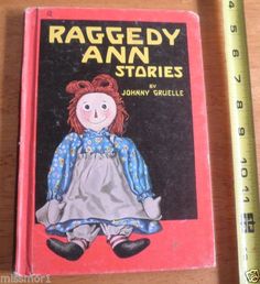 the raggedy ann stories book is next to a ruler